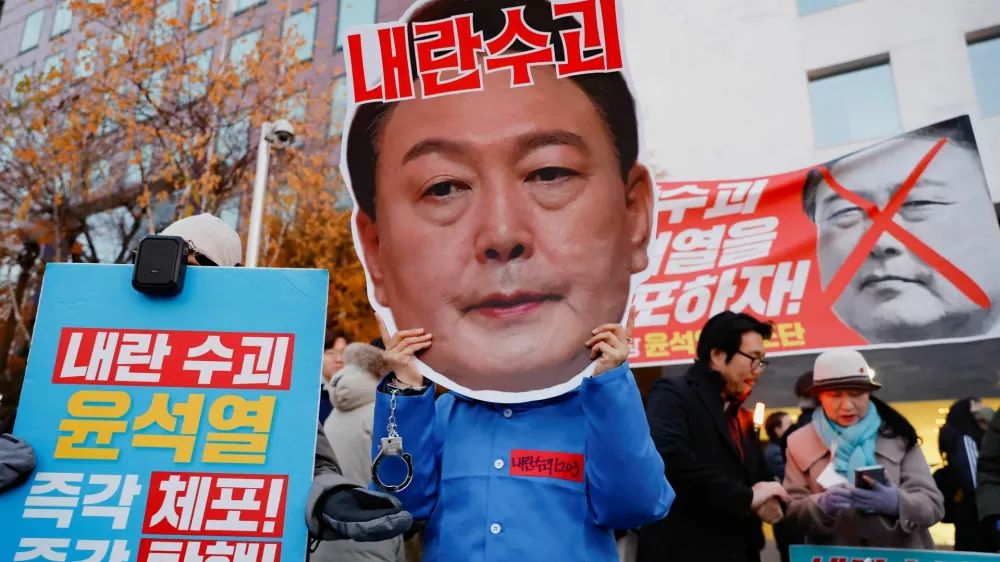 A protestor wears a face mask of South Korean President Yoon Suk Yeol in a rally calling for his impeachment, who declared martial law, which was reversed hours later, near the National Assembly in Seoul, South Korea, December 8, 2024. REUTERS/Kim Soo-hyeon