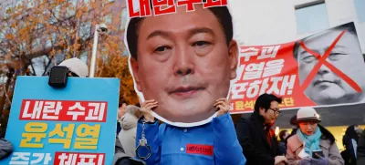 A protestor wears a face mask of South Korean President Yoon Suk Yeol in a rally calling for his impeachment, who declared martial law, which was reversed hours later, near the National Assembly in Seoul, South Korea, December 8, 2024. REUTERS/Kim Soo-hyeon