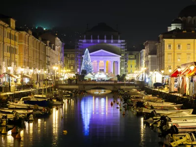 Trieste, Friuli Venezia Giulia, Italy - December 10, 2011: Italian city of Trieste on the Adriatic sea coast. Canal Grande over Ponte Rosso to the Sant'Antonio Nuovo Church in Christmas time night photograph.