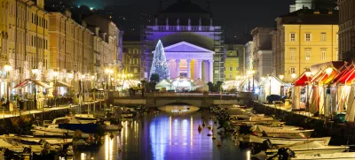 Trieste, Friuli Venezia Giulia, Italy - December 10, 2011: Italian city of Trieste on the Adriatic sea coast. Canal Grande over Ponte Rosso to the Sant'Antonio Nuovo Church in Christmas time night photograph.