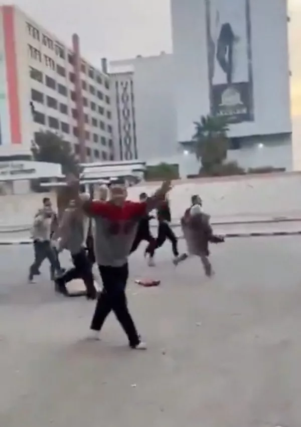 A person gestures as individuals, reportedly freed prisoners, run in the streets of Damascus, Syria, December 8, 2024, in this picture obtained from social media video. Nedal Al-Amari/via REUTERS THIS IMAGE HAS BEEN SUPPLIED BY A THIRD PARTY. MANDATORY CREDIT. NO RESALES. NO ARCHIVES.