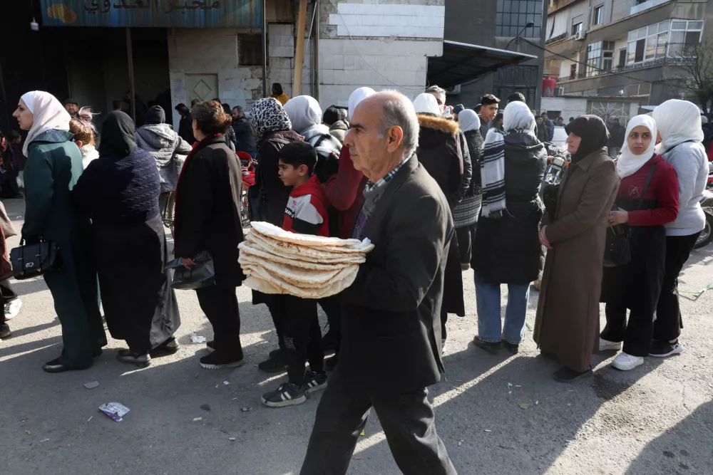 People queue to buy bread in Damascus, after rebels seized the capital and ousted Syria's Bashar al-Assad in Damascus, Syria December 9, 2024. REUTERS/Mohamed Azakir