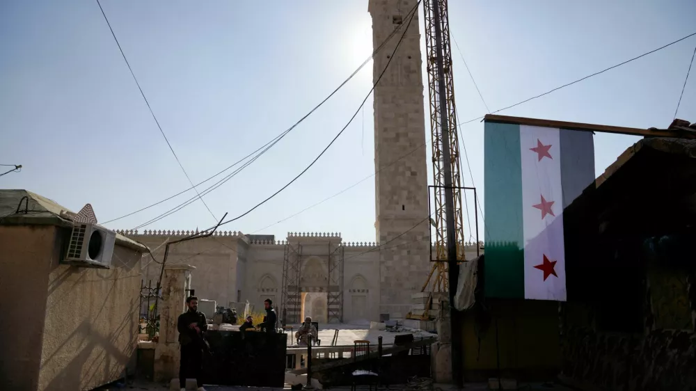 Rebel fighters with weapons keep watch at a barricade outside the Umayyad Mosque, after Syrian rebels announced that they have ousted Bashar al-Assad, in Aleppo, Syria, December 9, 2024. REUTERS/Karam al-Masri