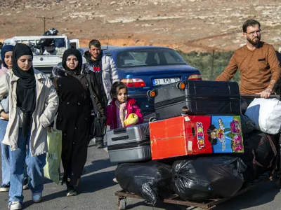 Syrian families arrive to cross into Syria from Turkey at the Cilvegozu border gate, near the town of Antakya, southern Turkey, Monday, Dec. 9, 2024. (AP Photo/Metin Yoksu)