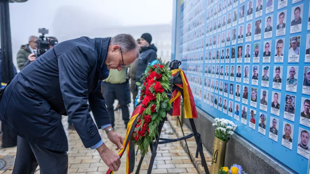 08 December 2024, Ukraine, Kiev: Friedrich Merz, CDU candidate for German chancellor and federal CDU chairman, stands at the Wall of Remembrance for the soldiers who died in the war on St. Michael's Square. Merz is spending a day in the Ukrainian capital. Photo: Michael Kappeler/dpa