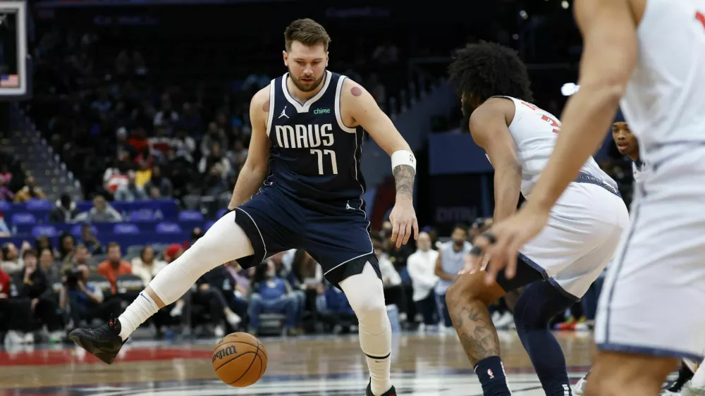 Dec 5, 2024; Washington, District of Columbia, USA; Dallas Mavericks guard Luka Doncic (77) dribbles the ball as Washington Wizards forward Marvin Bagley III (35) defends in the first quarter at Capital One Arena. Mandatory Credit: Geoff Burke-Imagn Images