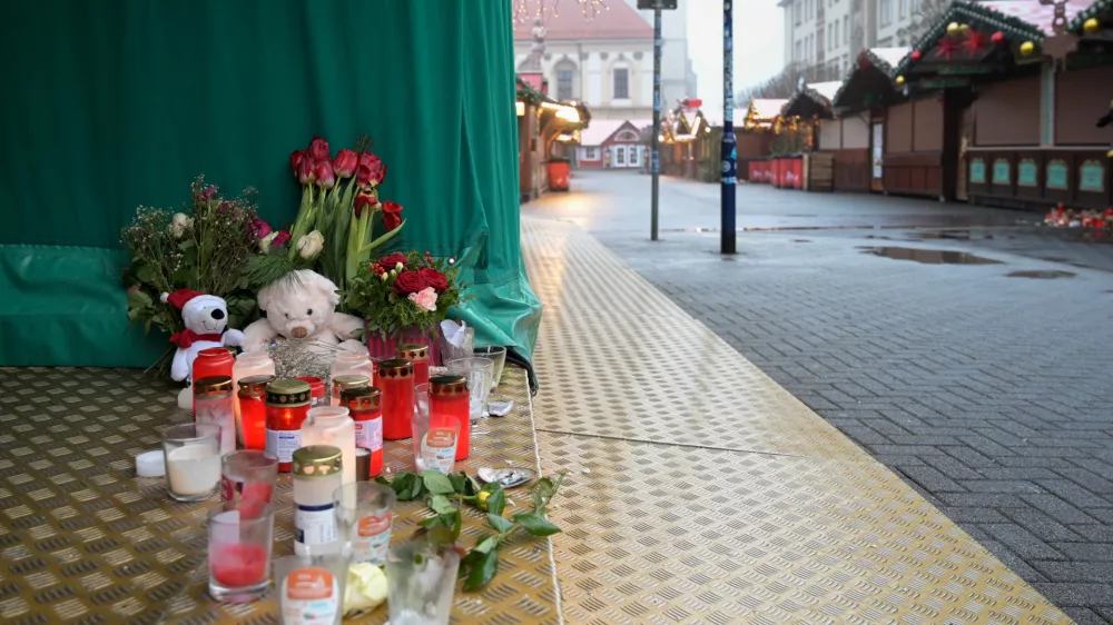 26 December 2024, Saxony-Anhalt, Magdeburg: Candles, cuddly toys and flowers are placed on the ground at a stand at the Christmas market as a tribute to the victims of Magdeburg Christmas market. After a car drove into a crowd of people at the Christmas market on 20.12.2024, the grief and consternation continues. Photo: Heiko Rebsch/dpa