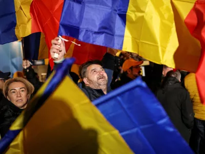 FILE PHOTO: A supporter of the radical right Alliance for Uniting Romanians (AUR) wave a Romanian flag, following the first exit polls, at the party's campaign headquarters, on the day of the parliamentary election, in Bucharest, Romania, December 1, 2024. REUTERS/Alkis Konstantinidis/File Photo