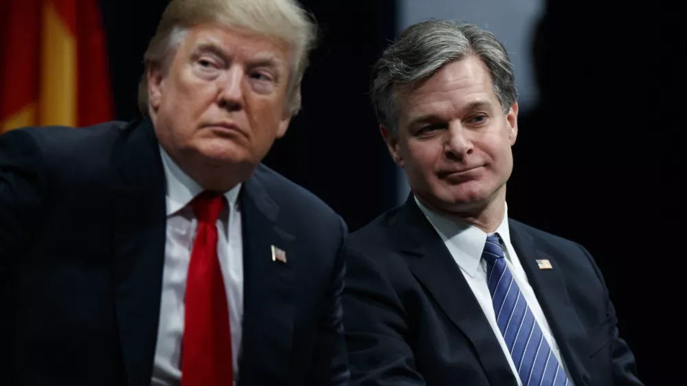 FILE - President Donald Trump sits with FBI Director Christopher Wray during the FBI National Academy graduation ceremony, Dec. 15, 2017, in Quantico, Va. (AP Photo/Evan Vucci, File)