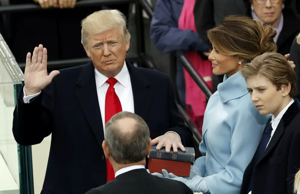 ﻿US President Donald Trump takes the oath of office with his wife Melania and son Barron at his side, during his inauguration at the U.S. Capitol in Washington, U.S., January 20, 2017. REUTERS/Kevin Lamarque