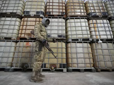 A Syrian member of the rebel group shows liquid material for manufacturing amphetamine pills known as Captagon hidden, at the warehouse where the drug was manufactured before the fall of Bashar Assad government at a facility in Douma city, outskirts of Damascus, Syria, Friday, Dec. 13, 2024. (AP Photo/Hussein Malla)