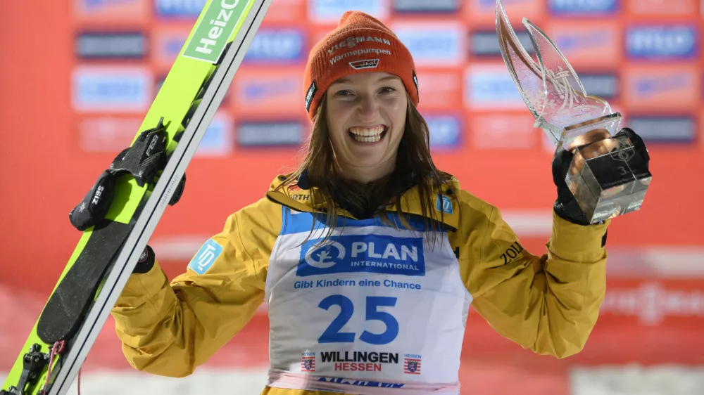 FILED - 03 February 2024, Hesse, Willingen: Katharina Schmid from Germany celebrates at the award ceremony of the women's Nordic skiing during the Ski Jumping World Cup. Schmid extended her overall lead after winning a women's normal hill World Cup ski-jumping event in the 2022 Winter Olympic venue of Zhangjiakou, China on 13 December. Photo: Swen Pförtner/dpa