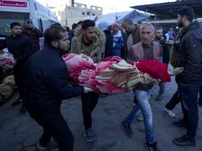 Palestinians carry the body of a relative killed in the Israeli bombardment of the Gaza Strip at a hospital in Deir al-Balah, Sunday, Dec. 15, 2024. (AP Photo/Abdel Kareem Hana)