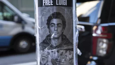 A poster depicting Luigi Mangione hangs outside the New York Hilton Midtown hotel, in New York, Dec. 12, 2024. (AP Photo/Julia Demaree Nikhinson)