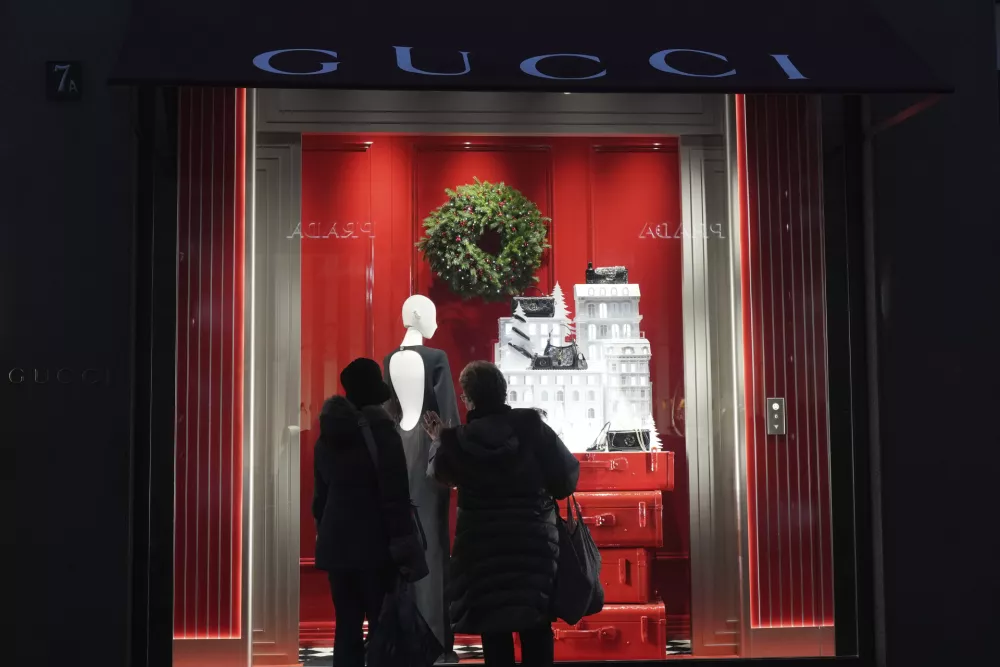 Women look a shop in Monte Napoleone street in Milan, Italy, Thursday, Dec. 12, 2024. (AP Photo/Antonio Calanni)