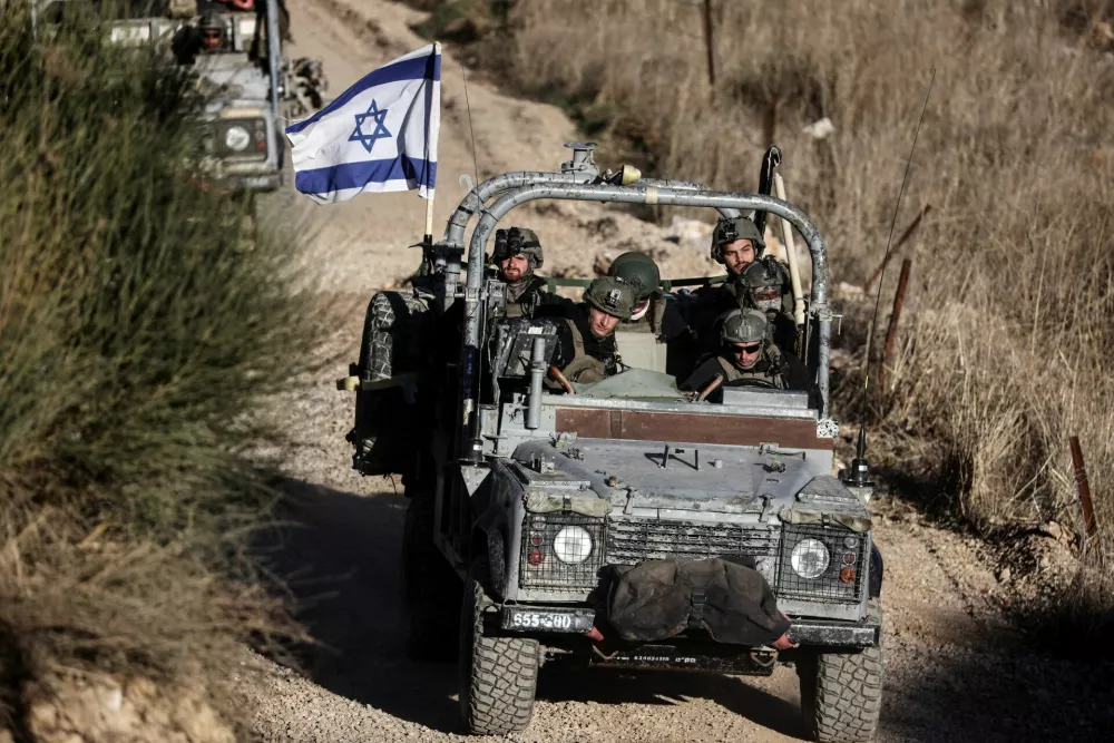 Israeli military vehicles ride through Syria close to the ceasefire line between the Israeli-occupied Golan Heights and Syria, as seen from Majdal Shams in the Golan Heights, December 15, 2024. REUTERS/Jamal Awad