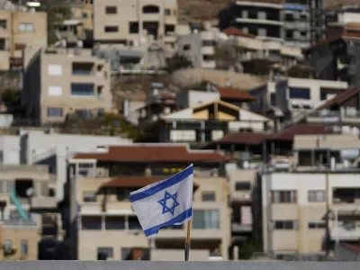 An Israeli flag flies on a roof in the town of Majdal Shams, near the so-called Alpha Line that separates the Israeli-controlled Golan Heights from Syria, Sunday, Dec. 15, 2024. (AP Photo/Matias Delacroix)