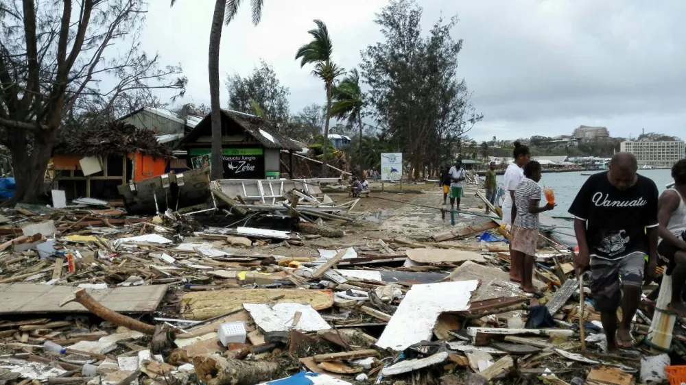 (150315) -- PORT VILA, March 15, 2015 (Xinhua) -- Locals walk past debris after Tropical Cyclone Pam wreaked havoc in Port Vila, Vanuatu, March 15, 2015. The cyclone-hit island nation of Vanuatu declared a state of emergency on Sunday after at least eight people were confirmed killed by Tropical Cyclone Pam, local press reported.(Xinhua/Luo Xiangfeng)(dh)