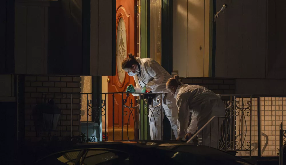 Technicians investigate a crime scene where police say multiple family members were found dead inside a home in West Valley City, Utah, Tuesday Dec. 17, 2024. (Scott G. Winterton/The Deseret News via AP)