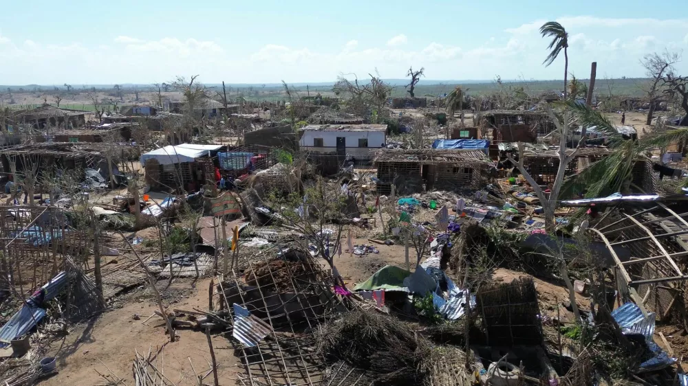 People stand amid destroyed buildings, uprooted trees and debris after cyclone Chido hit Mozambique, in Mecufi district, Cabo Delgado province, Mozambique, December 16, 2024, in this screengrab taken from a handout drone video. Unicef Mozambique/Handout via REUTERS  THIS IMAGE HAS BEEN SUPPLIED BY A THIRD PARTY NO RESALES. NO ARCHIVES. MANDATORY CREDIT