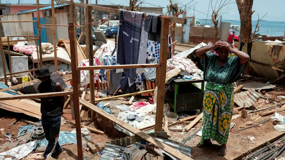 A woman reacts as she cleans her house in the aftermath of Cyclone Chido, in Mamoudzou, Mayotte, France December 18, 2024. REUTERS/Gonzalo Fuentes