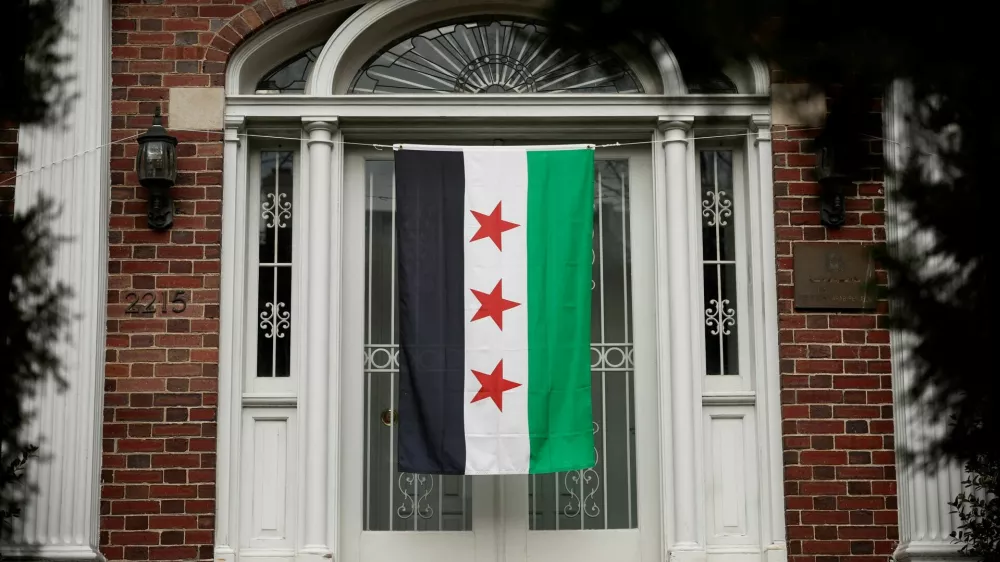 A Syrian opposition flag hangs on the entrance of the Syrian Embassy in Washington, U.S., December 18, 2024. REUTERS/Benoit Tessier