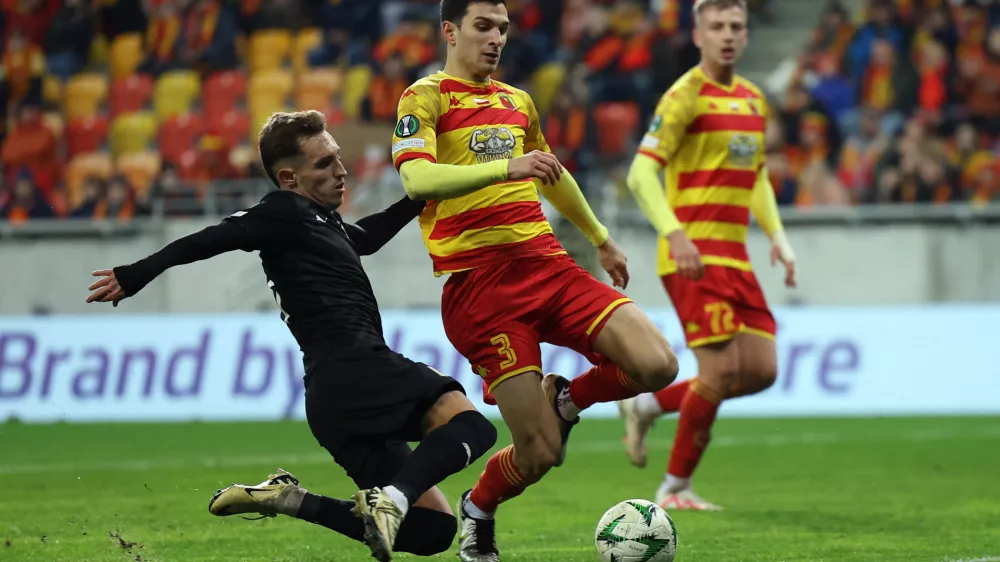 Soccer Football - Conference League - Jagiellonia Bialystok v Olimpija - Bialystok City Stadium, Bialystok, Poland - December 19, 2024 Jagiellonia Bialystok's Dusan Stojinovic in action with Olimpija's Alejandro Blanco REUTERS/Kacper Pempel