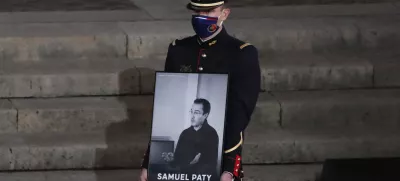 FILE - A Republican Guard holds a portrait of Samuel Paty in the courtyard of the Sorbonne university during a national memorial event, Wednesday, Oct. 21, 2020 in Paris. (AP Photo/Francois Mori, Pool, File)