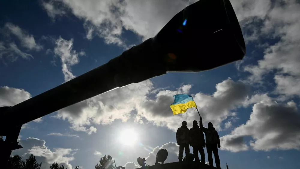 FILE PHOTO: Ukrainian personnel hold a Ukrainian flag as they stand on a Challenger 2 tank during training at Bovington Camp, near Wool in southwestern Britain, February 22, 2023. REUTERS/Toby Melville/File Photo