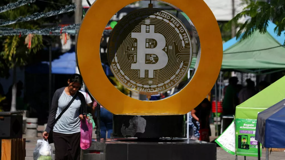 FILE PHOTO: A woman passes by the Bitcoin Monument after bitcoin soared above $100,000, in Ilopango, El Salvador, December 5, 2024. REUTERS/Jose Cabezas/File Photo