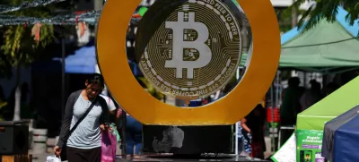 FILE PHOTO: A woman passes by the Bitcoin Monument after bitcoin soared above 0,000, in Ilopango, El Salvador, December 5, 2024. REUTERS/Jose Cabezas/File Photo