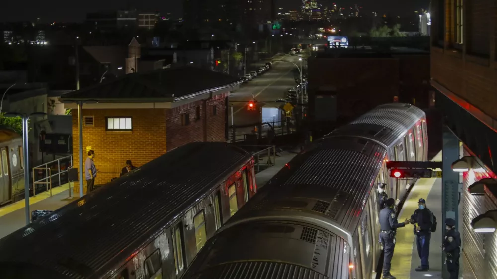 FILE - New York Police officers clear a train at the Coney Island Stillwell Avenue Terminal, May 5, 2020, in the Brooklyn borough of New York. (AP Photo/Frank Franklin II, file)