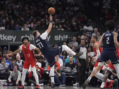 Dallas Mavericks guard Luka Doncic (77) shoots in front of Portland Trail Blazers guard Shaedon Sharpe (17) during the first half of an NBA basketball game Monday, Dec. 23, 2024, in Dallas. (AP Photo/LM Otero)