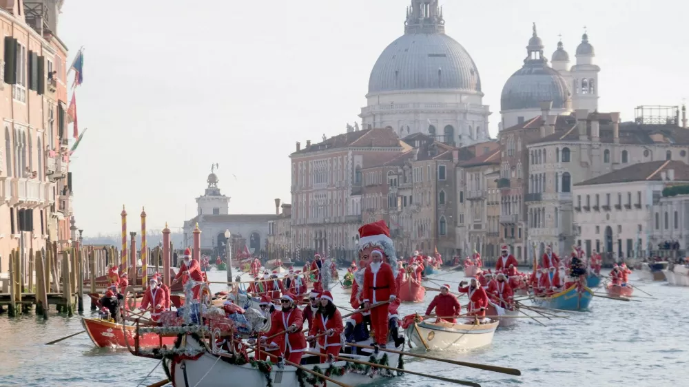 People dressed as Santa Claus row during a Christmas regatta along the Grand Canal in Venice, Italy, December 22, 2024. REUTERS/Manuel Silvestri   TPX IMAGES OF THE DAY