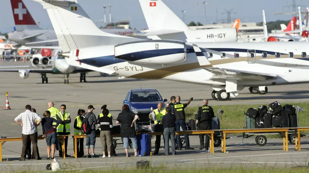 Passengers of an Airbus A-320 of the airline company Swiss International Airlines identify their lugage on the tarmac of the Cointrin airport in Geneva, Switzerland, Saturday, Aug. 23, 2008. The plane coming from Zurich and heading for Malaga, was forced to make an emergency landing in Geneva after an bomb threat from Spain. The plane with 142 passengers and six crew members on board landed safely at Geneva airport. All passengers left the plane by escape slides and were unharmed. The author and the motif of the threat are still unknown. (A Photo/KEYSTONE/Salvatore Di Nolfi)