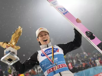 Ryoyu Kobayashi, of Japan, smiles with his trophy after winning the 72th Four Hills ski jumping tournament in Bischofshofen, Austria, Saturday, Jan. 6, 2024. (AP Photo/Matthias Schrader)