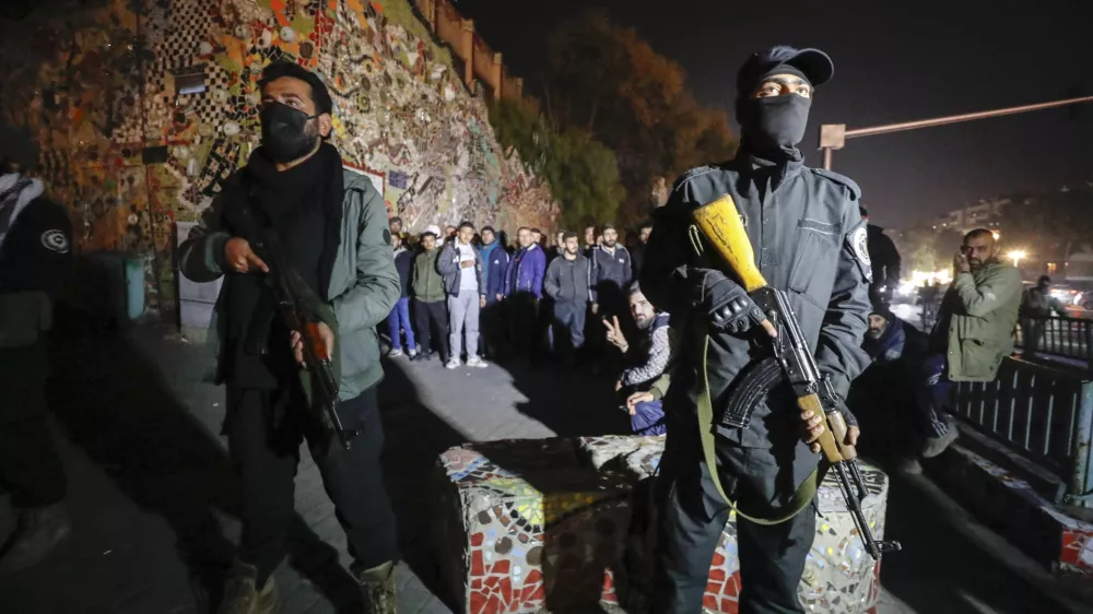 Security forces of the new Syrian government secure the area around group of Alawite protesters in the Mazzeh district in Damascus Wednesday Dec. 25, 2024. The minority Alawite community is an offshoot of Shiite Islam that form President Bashar Assad belongs to. (AP Photo/Omar Sanadiki)