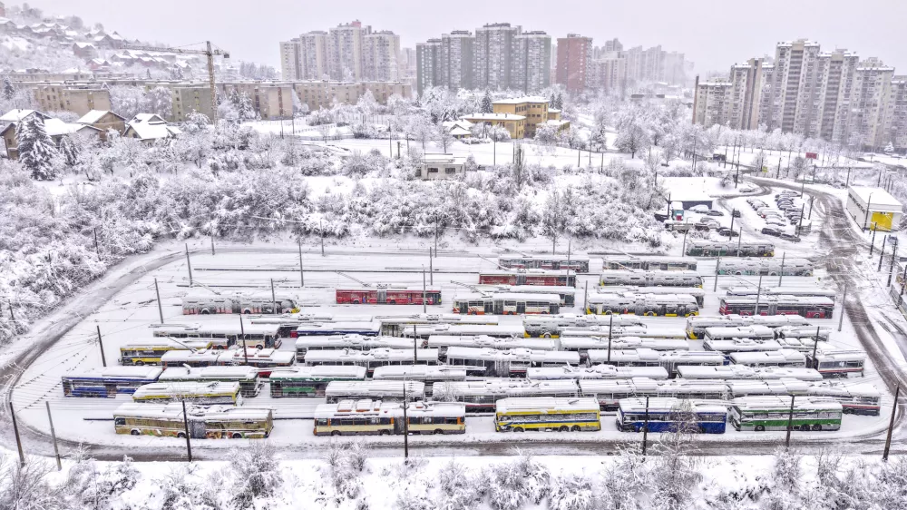 An aerial view of parked trolley buses during heavy snowfall in Sarajevo, Bosnia, Tuesday, Dec. 24, 2024. (AP Photo/Armin Durgut)