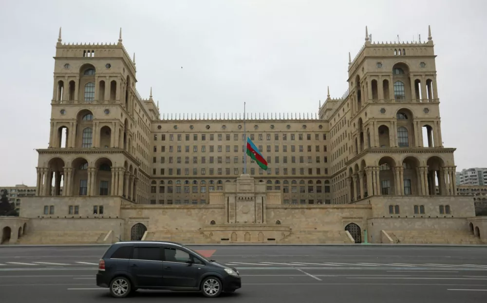 An Azeri state flag flies at half-mast as the country observes the day of national mourning for the victims of an Azerbaijan Airlines' Embraer passenger plane crash near the Kazakh city of Aktau, outside the Government House in Baku, Azerbaijan, December 26, 2024. REUTERS/Aziz Karimov