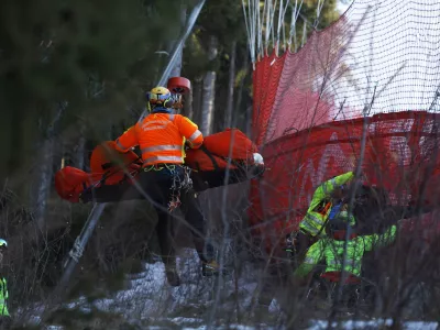 Medical staff are carrying France's Cyprien Sarrazin after crashing into protections net during an alpine ski, men's World Cup downhill training, in Bormio, Italy, Friday, Dec. 27, 2024. (AP Photo/Alessandro Trovati)