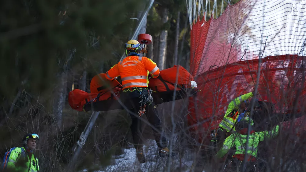 Medical staff are carrying France's Cyprien Sarrazin after crashing into protections net during an alpine ski, men's World Cup downhill training, in Bormio, Italy, Friday, Dec. 27, 2024. (AP Photo/Alessandro Trovati)