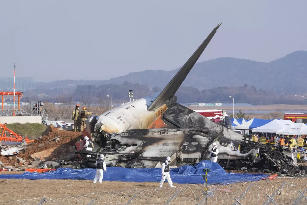 Firefighters and rescue team members work near the wreckage of a passenger plane at Muan International Airport in Muan, South Korea, Sunday, Dec. 29, 2024. (AP Photo/Ahn Young-joon)