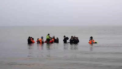 FILE - A group of Kurdish migrants from Iran and Iraq who failed in their attempt to reach the United Kingdom by boat after being discovered by the police refuse to return to shore on the beach of Ambleteuse, northern France, on May 19, 2024. (AP Photo/Bernat Armangue, File)