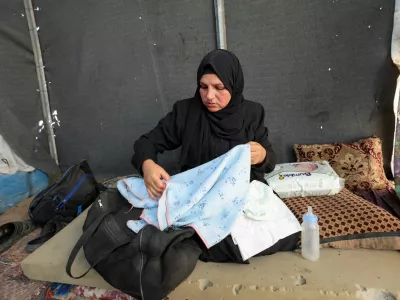 Noura, the mother of Palestinian infant Jumaa Al-Batran, who died of hypothermia after living in a tent with his displaced family, shows his belongings at their tent, in Deir Al-Balah in the central Gaza Strip, December 29, 2024. REUTERS/Ramadan Abed