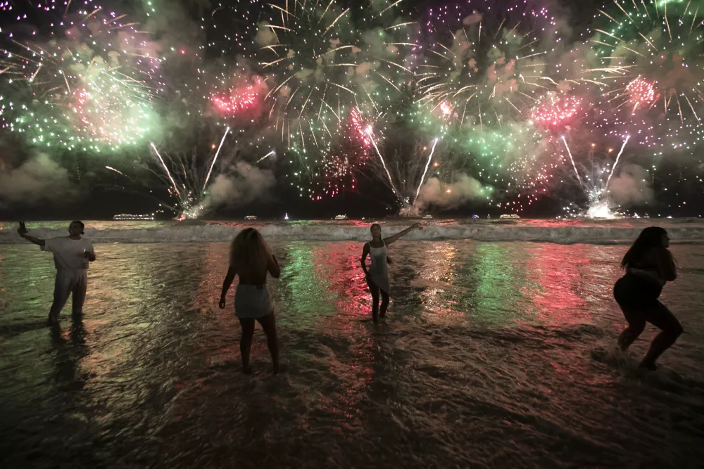 FILE - People celebrate the start of the New Year as fireworks illuminate Copacabana Beach in Rio de Janeiro, Brazil, early Monday, Jan. 1, 2024. (AP Photo/Bruna Prado, File)