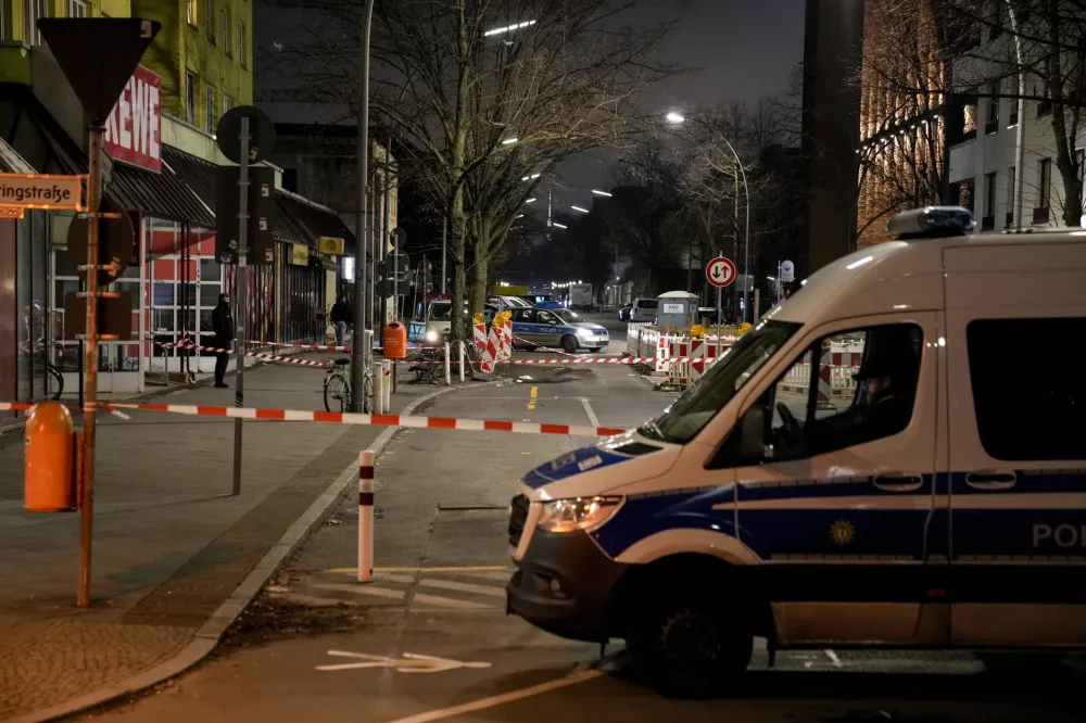 Police officers stand guard in front of a Rewe Market after a knife attack, in Berlin, Germany, Tuesday, Dec. 31, 2024. (AP Photo/Ebrahim Noroozi)