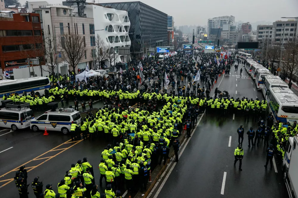 Police stand guard, blocking the road leading to the official residence of impeached South Korean President Yoon Suk Yeol as protesters gather, in Seoul, South Korea, January 5, 2025. REUTERS/Tyrone Siu