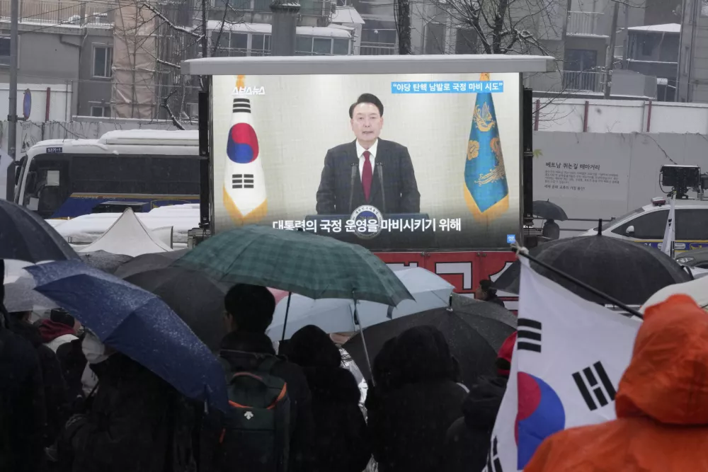 A TV screen shows a file image of South Korean President Yoon Suk Yeol as supporters of impeached Yoon attend a rally to oppose his impeachment near the presidential residence in Seoul, South Korea, Sunday, Jan. 5, 2025. (AP Photo/Ahn Young-joon)