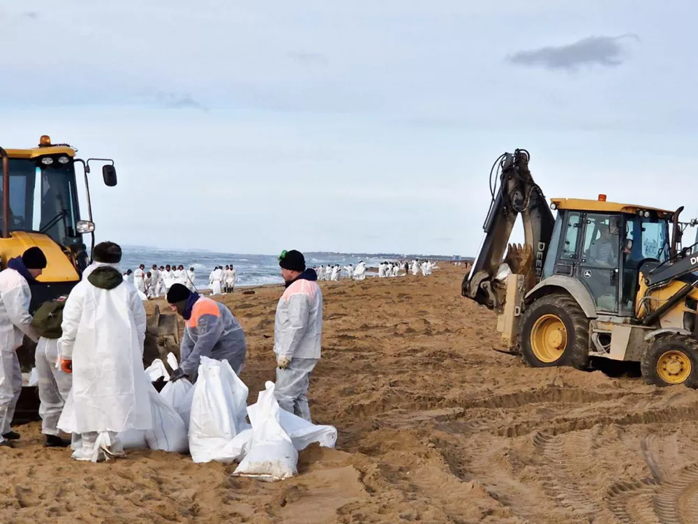 In this photo released by Krasnodar Gov. Veniamin Kondratyev in his Telegram channel on Sunday, Jan. 5, 2025, rescuers and volunteers work to clean up tons of fuel oil that spilled out of two storm-stricken tankers more than two weeks ago in the Kerch Strait, near Anapa in Russia's southern Krasnodar region. (Krasnodar Gov. Veniamin Kondratyev Telegram channel via AP)