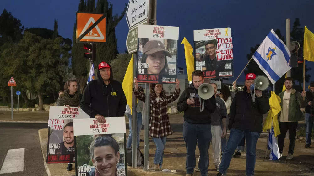 Israeli demonstrators outside the prime minister's office in Jerusalem hold photos of Liri Albag and other hostages during a protest calling for their release from being held in the Gaza Strip by the Hamas militant group, Sunday, Jan. 5, 2025. (AP Photo/Ohad Zwigenberg)